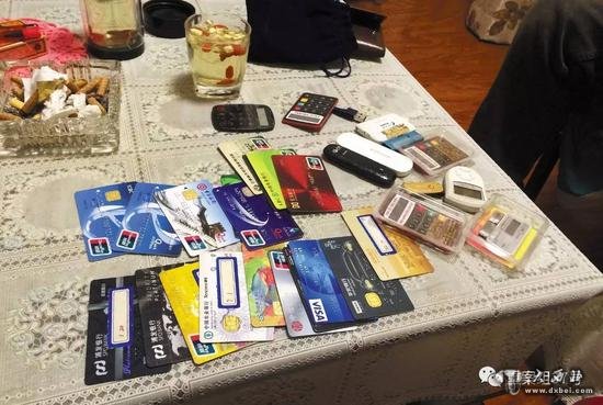 11月28日晚，燕郊东方夏威夷南岸二期10号楼501室，一名C1家长（传销头目）向刘奇等人展示自己的18 张银行卡和信用卡。    新京报记者大路摄